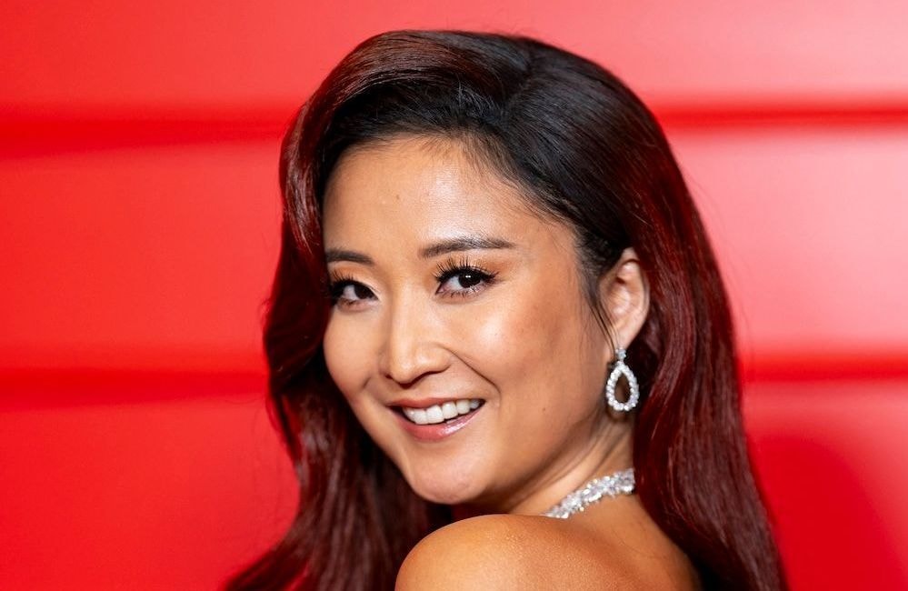 Coloration « Cherry Cola » et racines noires : Ashley Park mêle deux grandes tendances capillaires et signe un look glamour