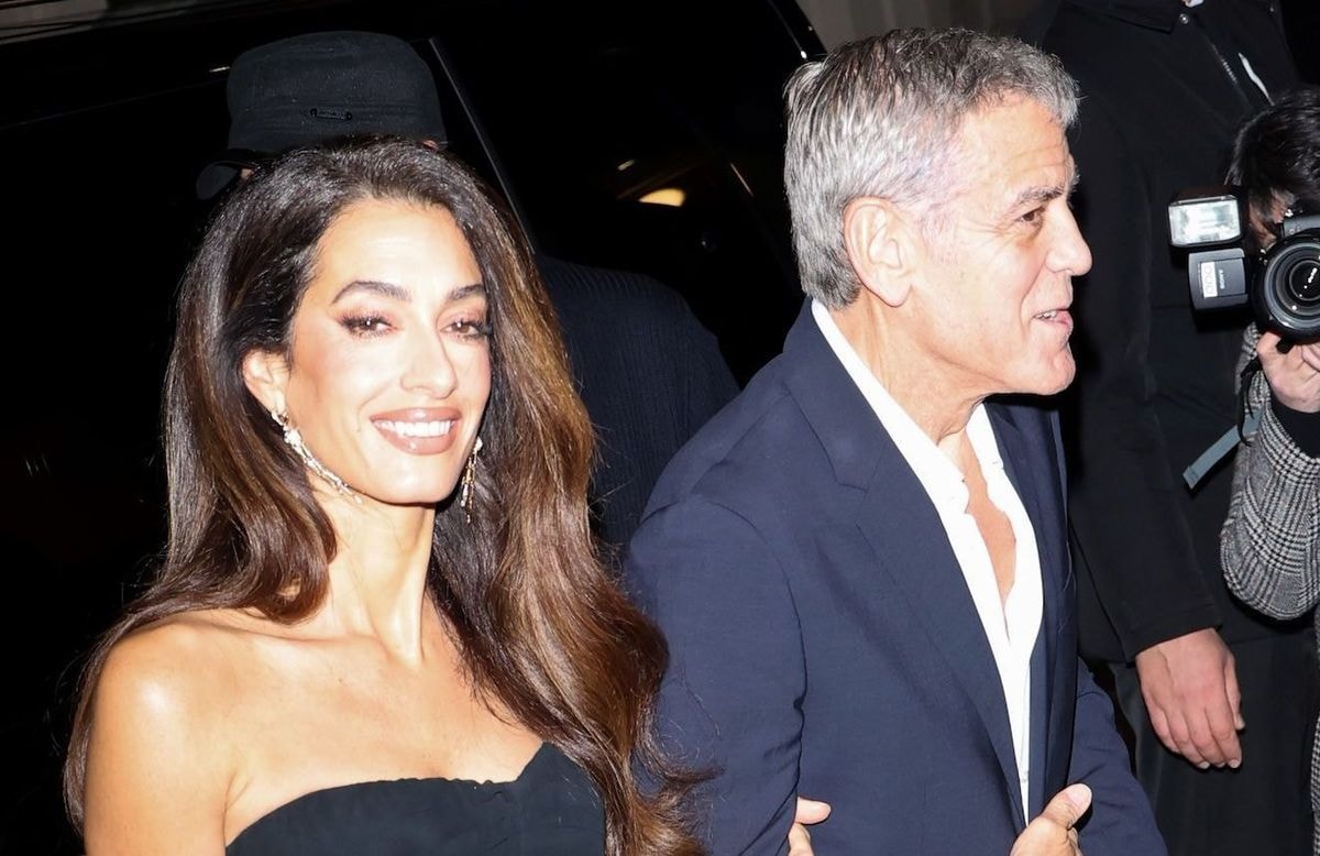 En slip dress noire fleurie, Amal Clooney nous donne envie d’abandonner la robe blanche pour nos soirées d’été